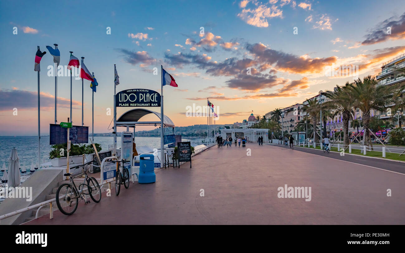 Nizza, Frankreich - 23. Mai 2018: Blick auf den Strand und das Mittelmeer Küste mit berühmten Hotel Negresco im Hintergrund bei Sonnenuntergang, Cote d'Azur, Stockfoto