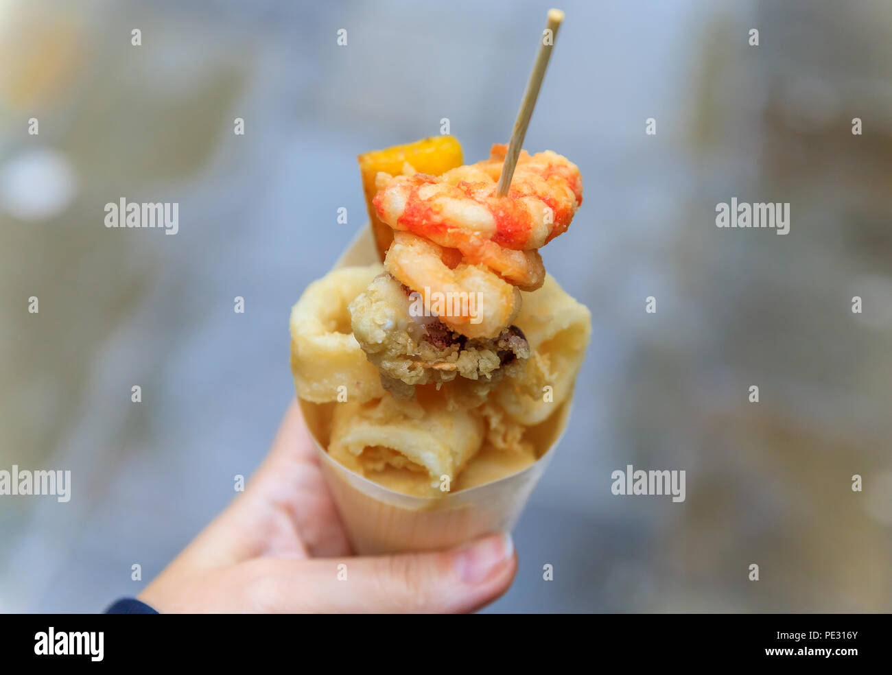 Italienisches Straßenessen in Venedig - Fritto Misto (Mischung aus gebratenem Fisch, Kalamari oder Tintenfisch und Garnelen) in einem Kegel unterwegs Stockfoto