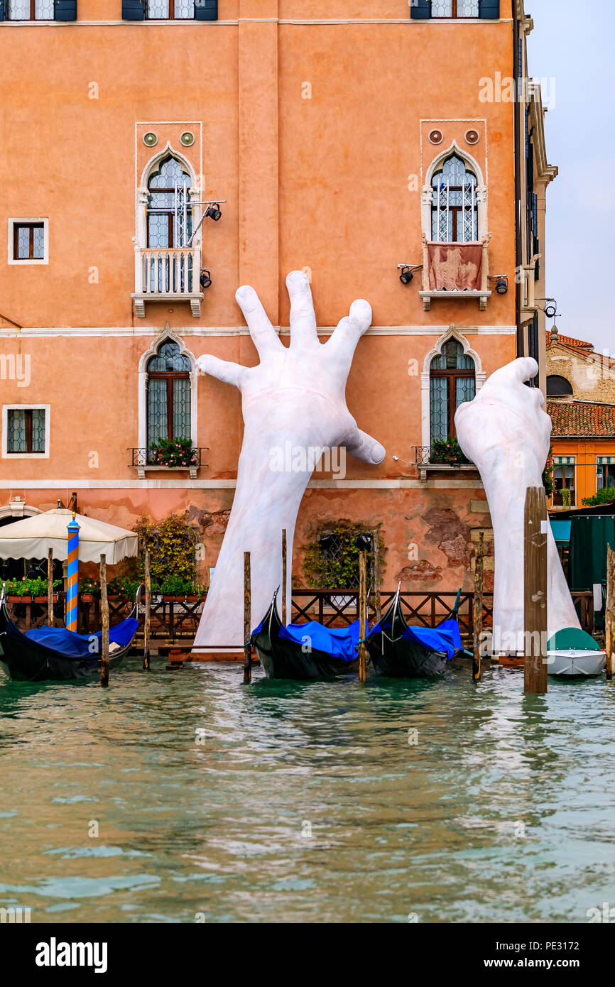 Venedig, Italien, 24. September 2017: Gondeln entlang einer malerischen Fassade eines Gebäudes im venezianischen Gotik mit der Skulptur der Hände geparkt, sup Stockfoto