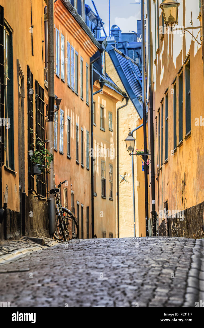 Schweden malerische Straße mit Kopfsteinpflaster im malerischen Gamla Stan, Stockholms älteste Nachbarschaft. Geparkt Fahrrad gegen ein Gebäude lehnend. Radfahren ist ein po Stockfoto