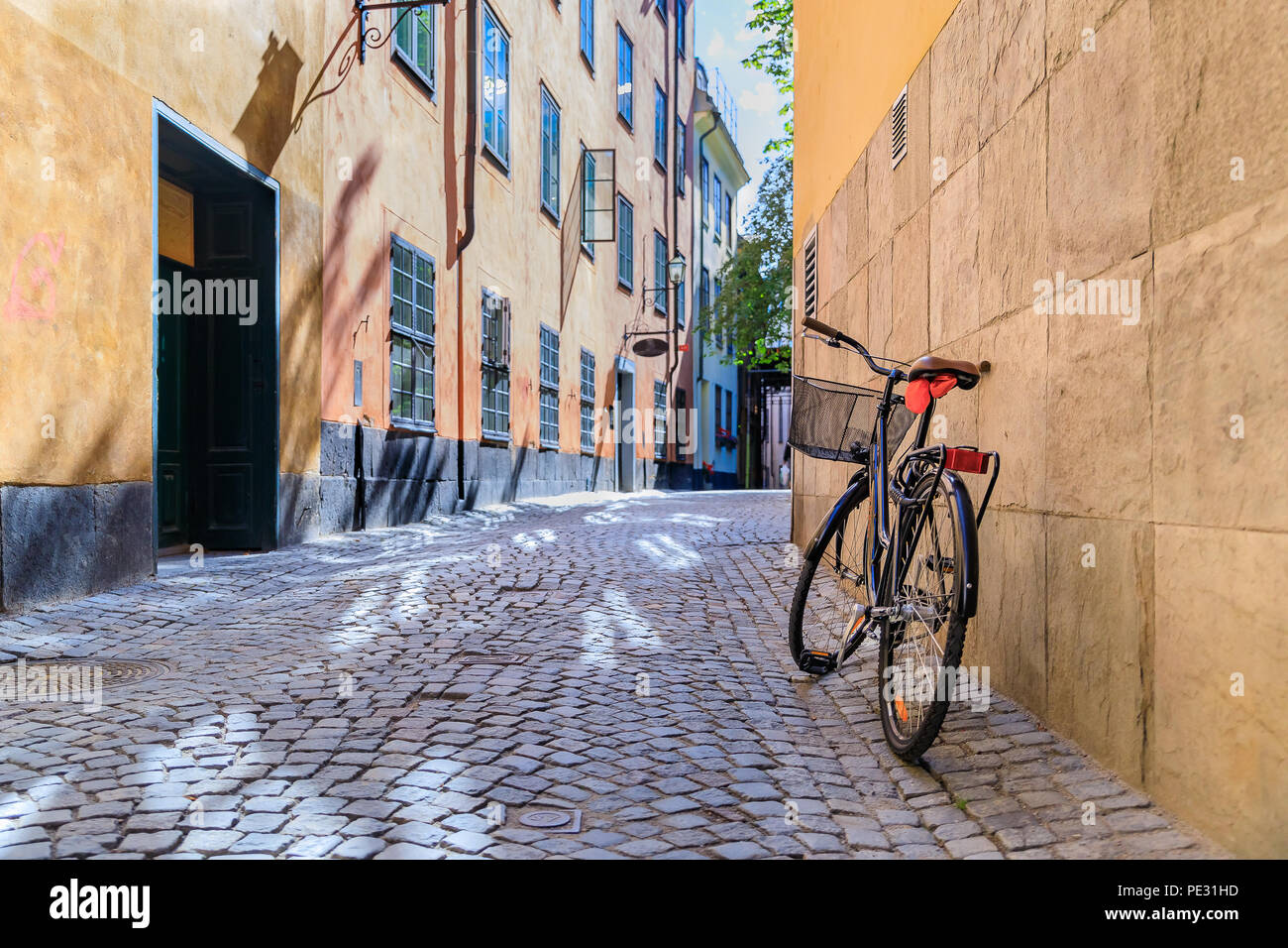 Schweden malerische Straße mit Kopfsteinpflaster im malerischen Gamla Stan,  Stockholms älteste Nachbarschaft. Geparkt Fahrrad gegen ein Gebäude  lehnend. Radfahren ist ein po Stockfotografie - Alamy