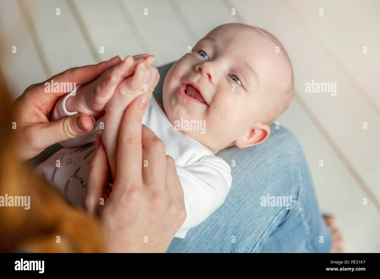 Neugeborene Kind liegt auf Mutter Schoß. Mutter Kind baby boy Holding. Frau und Sohn Entspannen und Spielen in Weiß helles Schlafzimmer. Familie, Mutterschaft, tendern Stockfoto