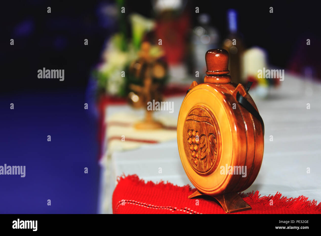 Holz- Flasche mit nationalen Symbolen Götzen auf Holz (traditionelle rumänische und moldauischen Kolben). Weinblätter und Weintrauben graviert auf ein halbes. Stockfoto