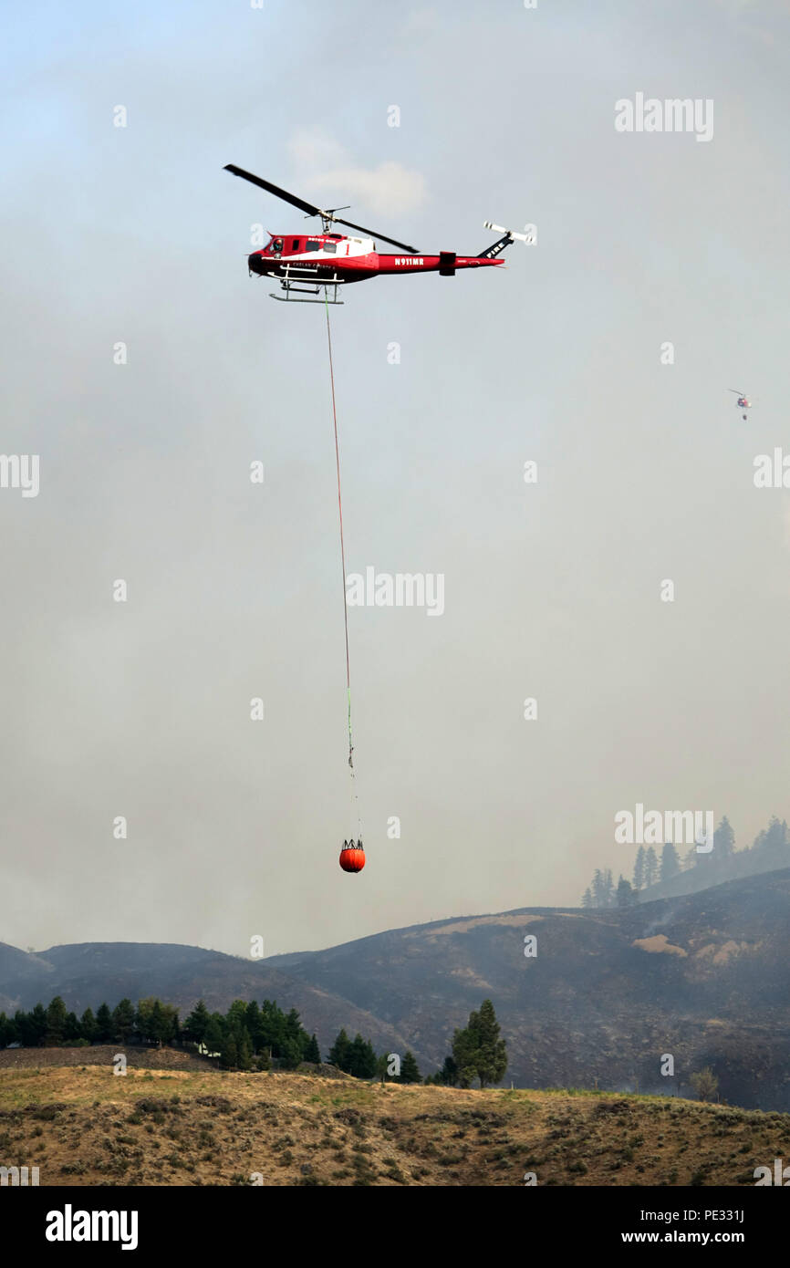 Hubschrauber sind eine primäre Antenne support System wildfires, indem sie Wasser auf Aktive firelines zu helfen Feuerwehrmänner Kontrolle gewinnen zu kämpfen. Stockfoto