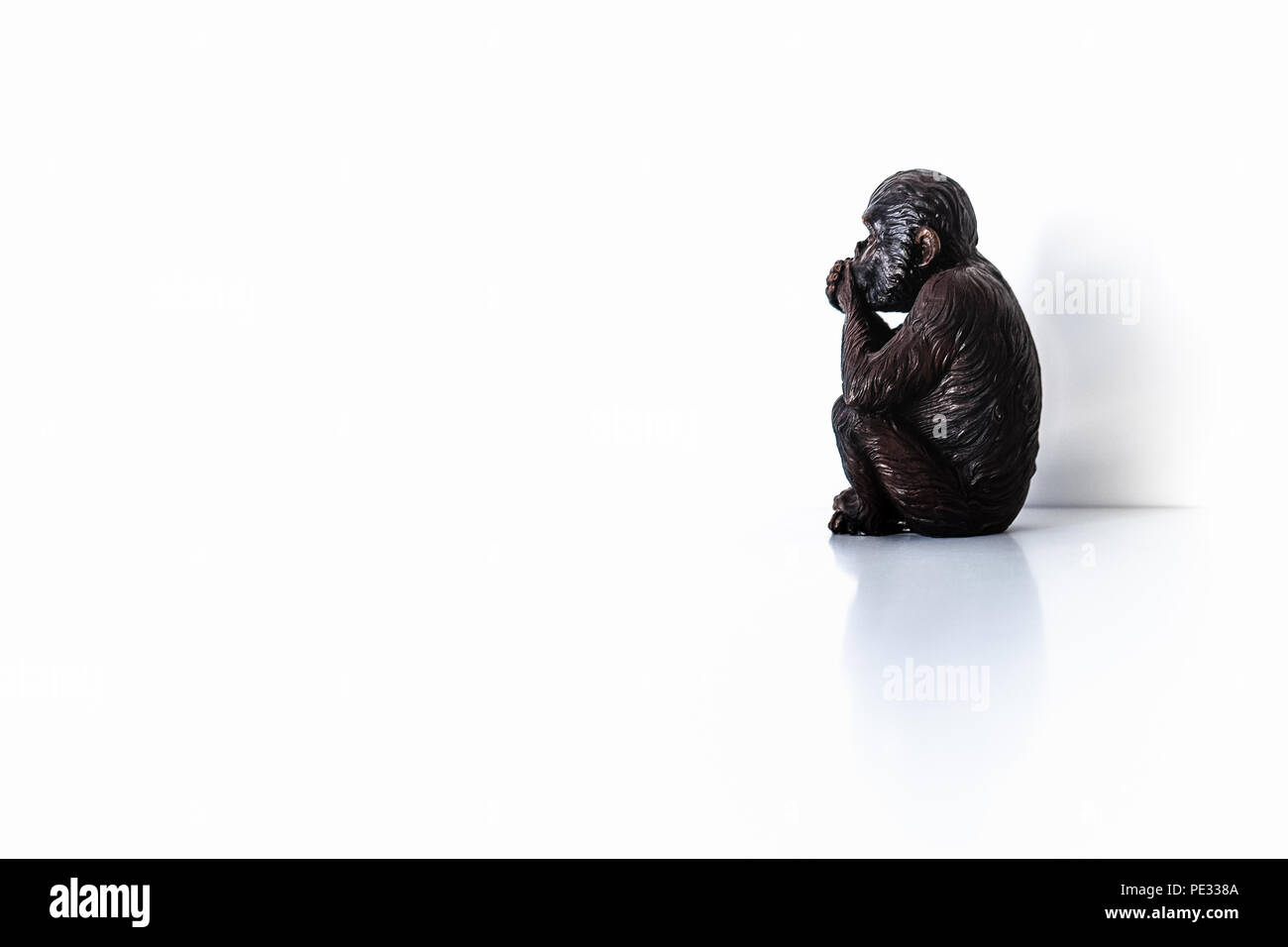Nachdenkliche single Affe, Affe statuette auf weißem Hintergrund Stockfoto