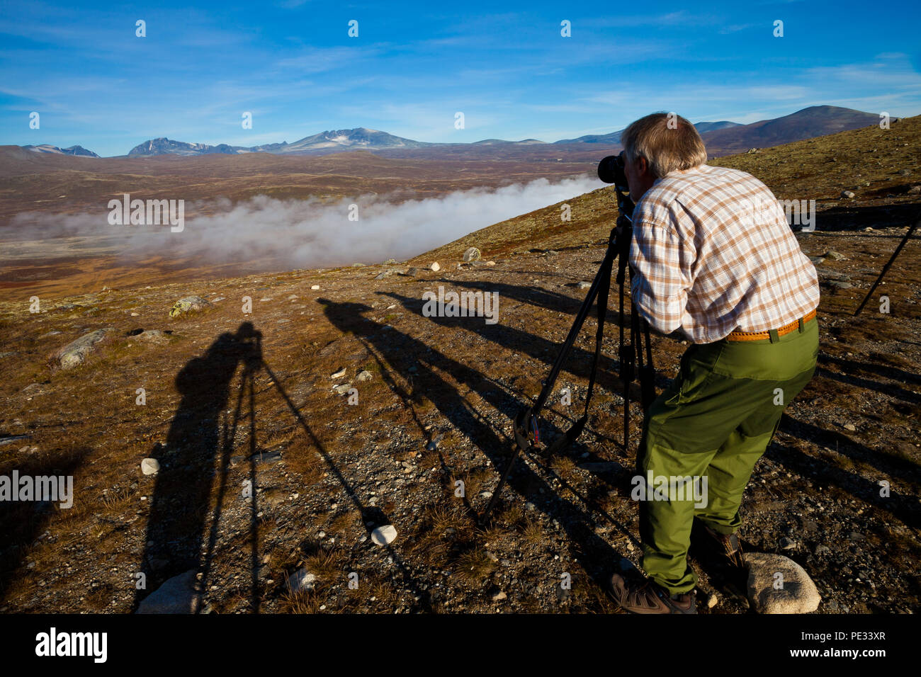 Ein Fotograf ist das Aufnehmen von Fotos bei View Point Snøhetta in Dovrefjell Nationalpark Dovrefjell, Norwegen. Stockfoto