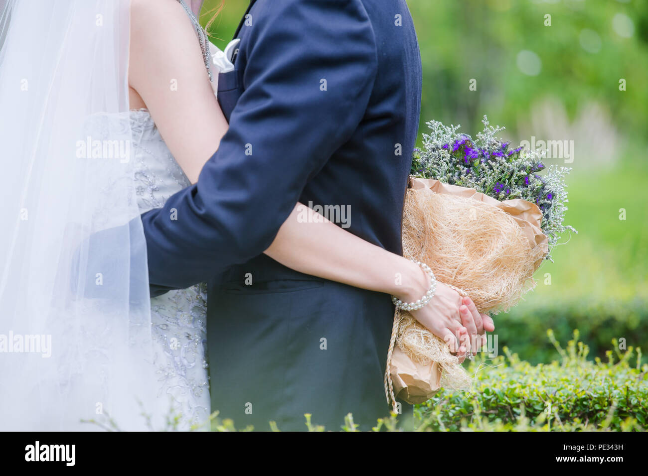 Brautpaar mit einem Strauß Blumen ist das Symbol der Liebe und der Ehe. Stockfoto