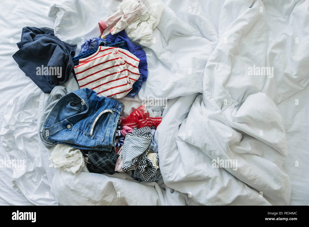 Close up Kleidung und Accessoires auf ungemachten Bett geworfen Stockfoto