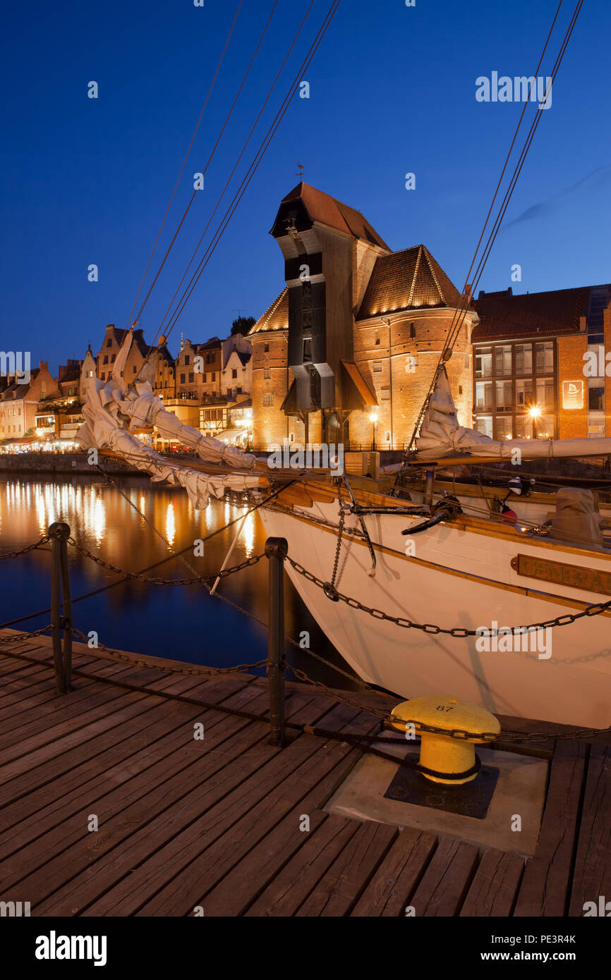 Der Danziger Altstadt Skyline bei Nacht mit dem Kran und angelegtes Segelschiff, alte Hafenstadt an der Mottlau auf Ostseeküste in Polen Stockfoto