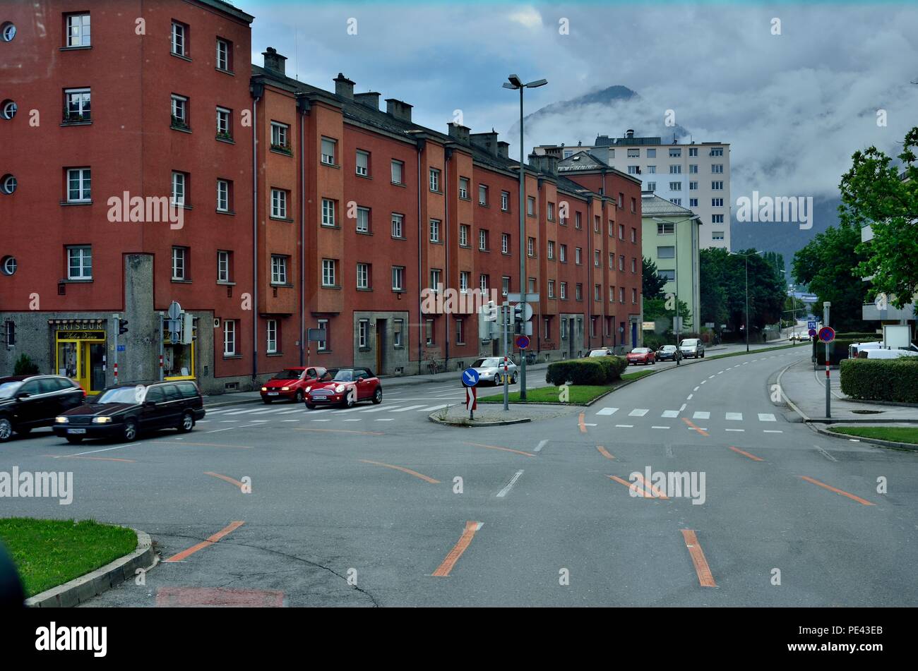 Eine typische Straßenszene, Brick Rotes Gebäude, Friseursalon Karin Durnthaler, Alpen Gebirgszüge im Hintergrund, Innsbruck, Österreich, Europa Stockfoto