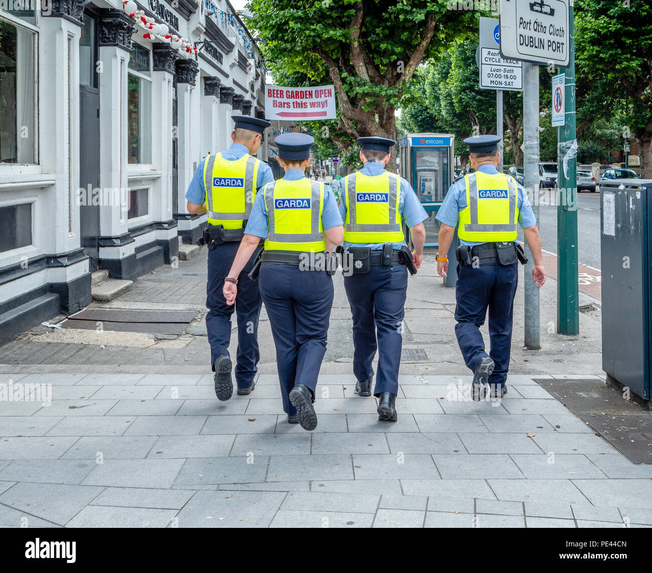 Vier gardasee Offiziere in Hi-viz Jacken vorbei gehen. ein Pub in Dublin am Spieltag in der Republik Irland Stockfoto