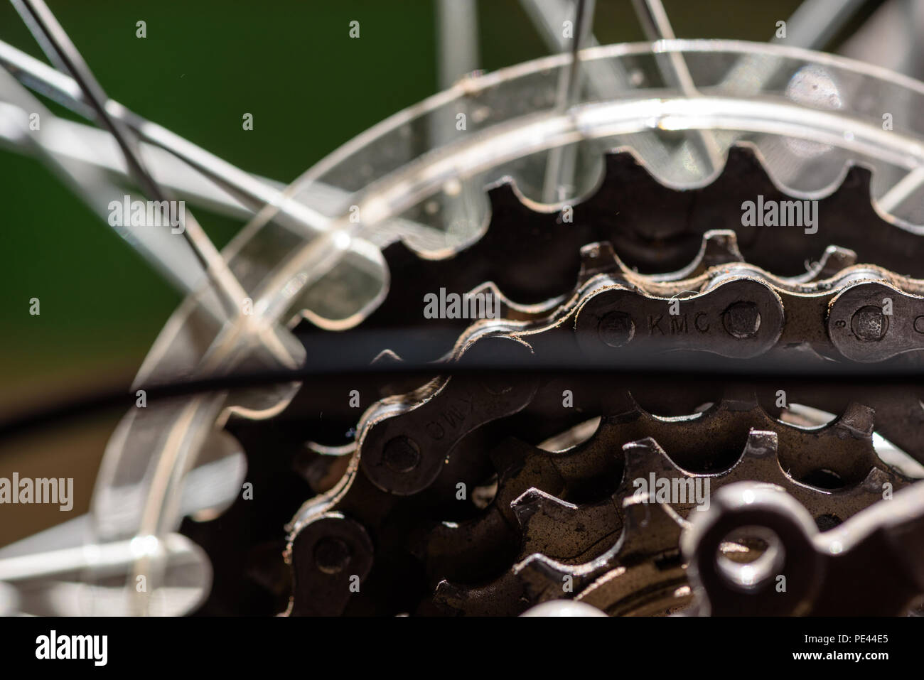 Closeup Bild der mechanischen Teile eines Bikes hinteren Zahnrad cog-System mit der Kette in einem gebrauchten Zustand und die Speichen des Rahmens und die sichtbaren i Stockfoto