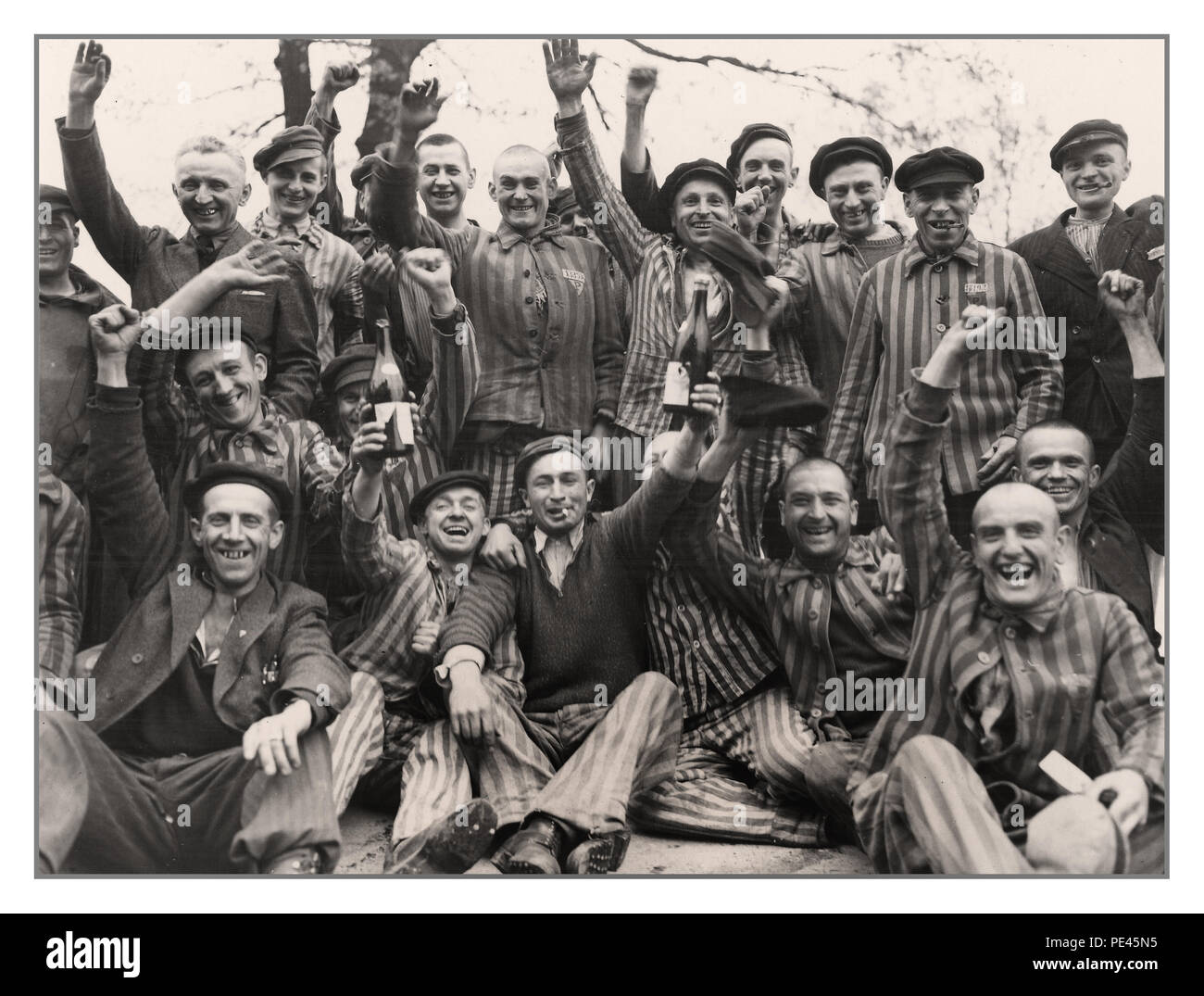 BEFREIUNG VON DACHAU Polnische Gefangene im KZ Dachau, einige in gestreifter Uniform, feierten ihre Befreiung als alliierte Soldaten das Lager am 29. April 1945 befreiten, wurde Dachau an Brig übergeben. General Henning Linden von der US-Armee der Infanterie-Division 42. durch Untersturmführer Wicker. Während des Zweiten Weltkriegs veröffentlichte General D. Eisenhower ein Kommuniqué über die Gefangennahme des Konzentrationslagers Dachau: „Unsere Truppen befreiten und moppten das berüchtigte Konzentrationslager Dachau. Etwa 32.000 Gefangene wurden befreit, 300 SS-Lagerwachen wurden schnell neutralisiert. Stockfoto