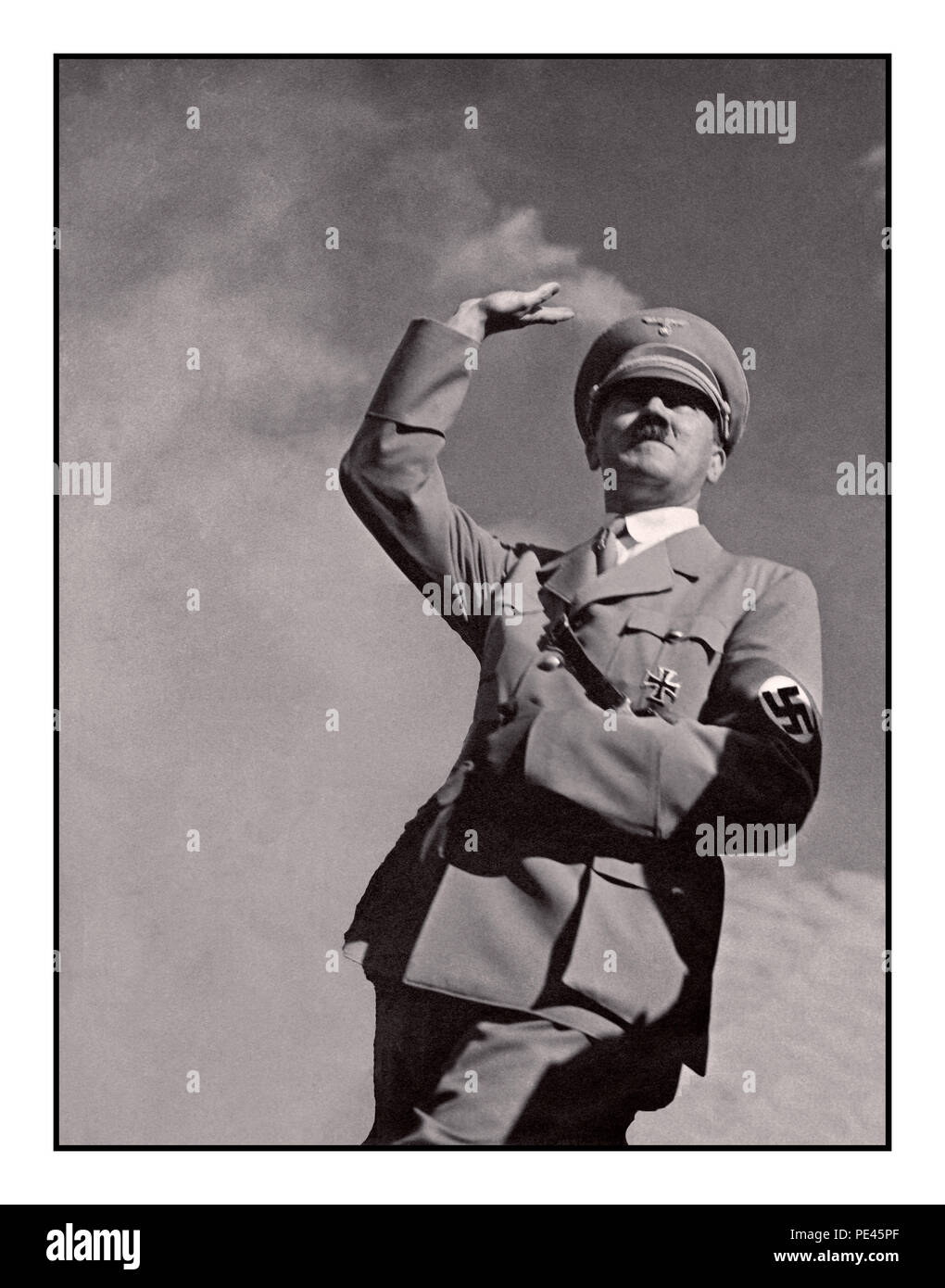 ADOLF HITLER SALUTE 1939 WW2 Deutsche Propaganda Bild von Adolf Hitler in Uniform tragen eines NS-Hakenkreuz armbinde Salutierte "Heil Hitler" zu einer Masse Low Angle View mit Himmel Hintergrund Stockfoto