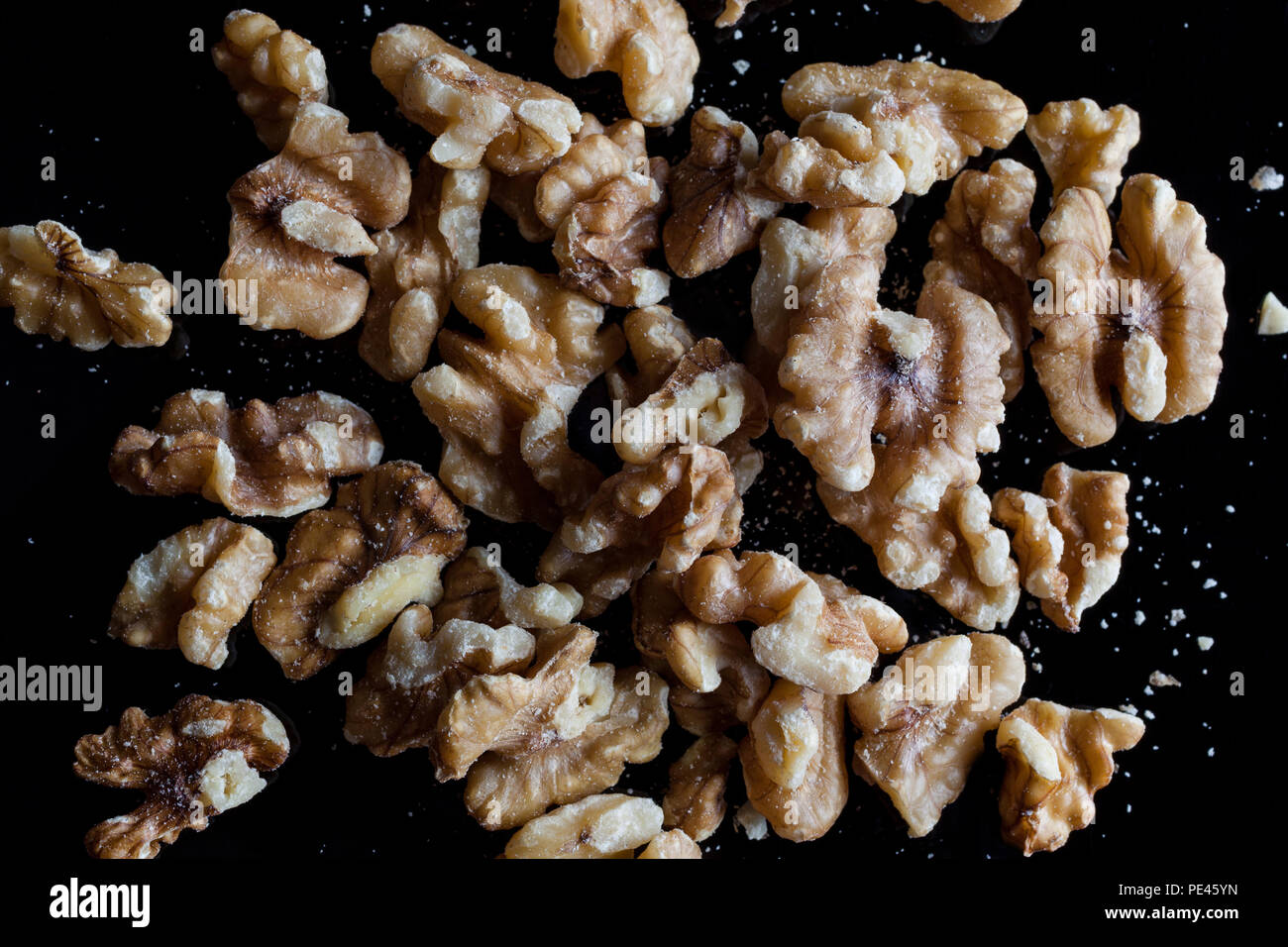 Ohne Schale Walnüsse auf schwarzem Hintergrund direkt von oben Stockfoto