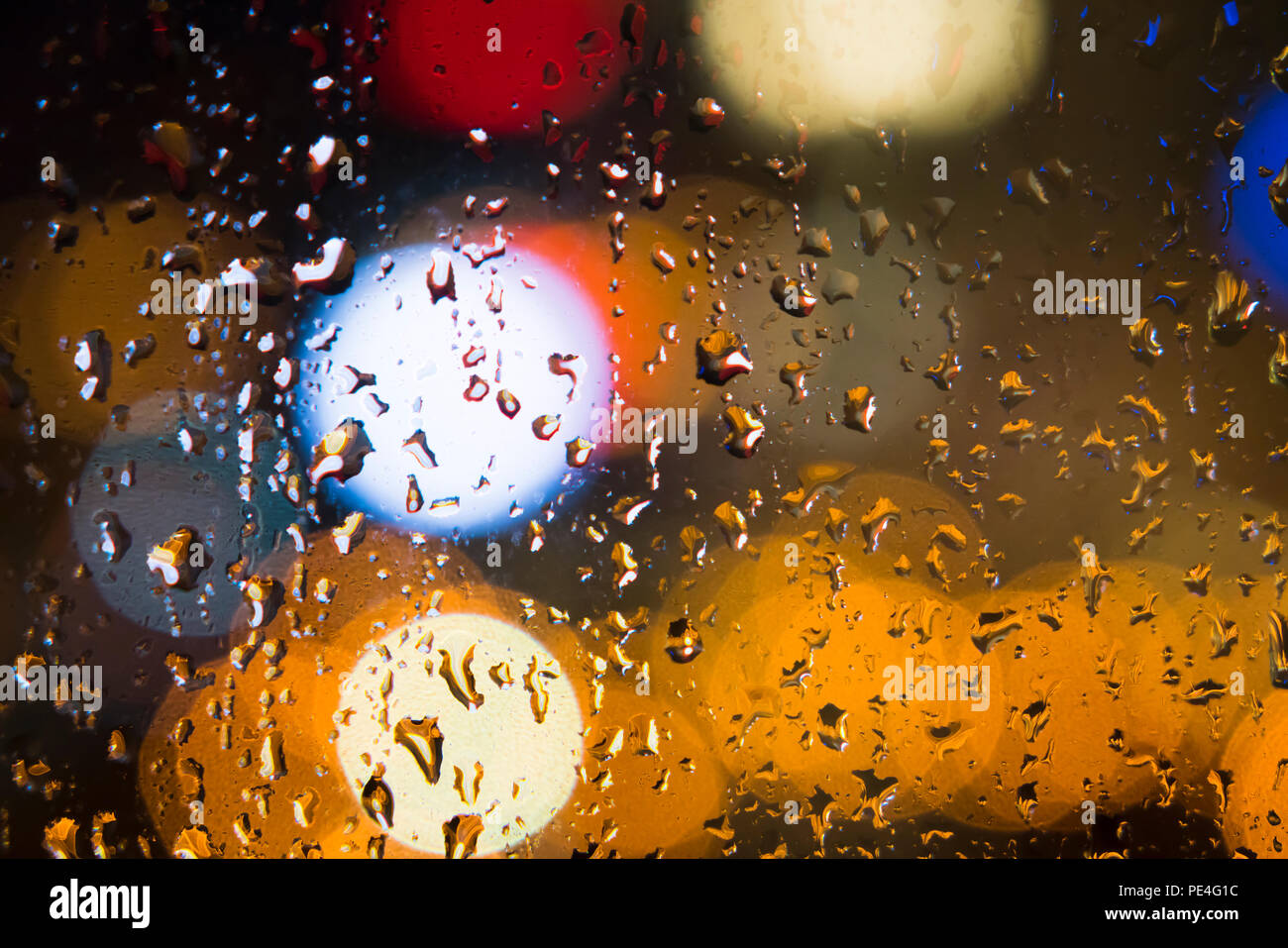 Regentropfen auf Fenster mit bunten bokeh Hintergrund Stockfoto