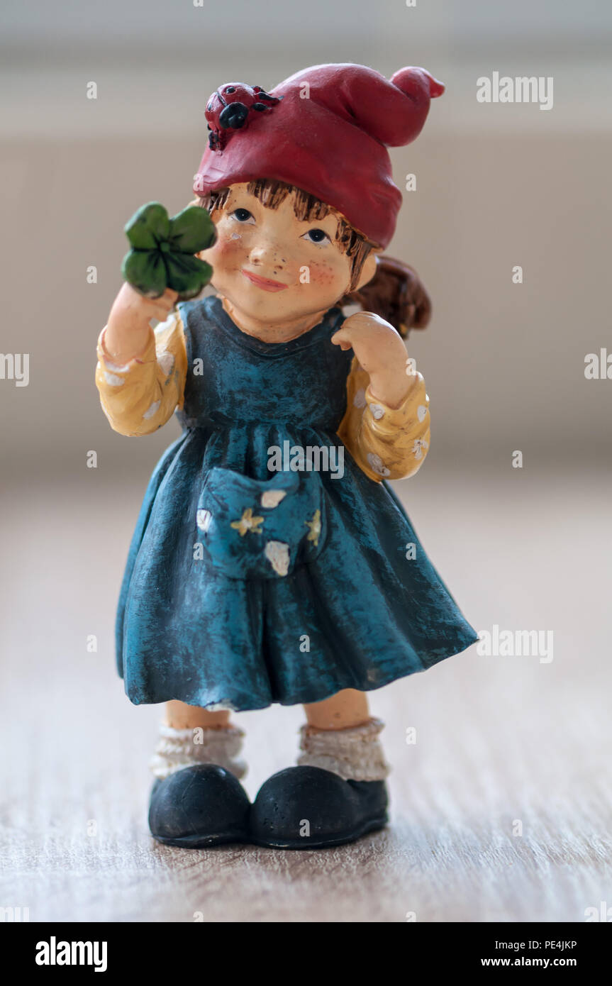 Close-up ein Gartenzwerg mit einem glücksklee auf einem Holztisch Stockfoto