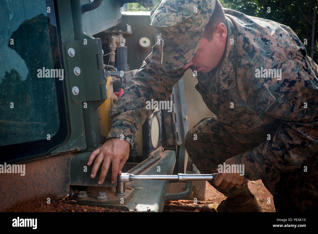 Cpl. Ewald Van Biljon, eine schwere Ausrüstung Mechaniker mit dem besonderen Zweck Marine Air-Ground Task Force und einem Roswell, Georgia, native, entfernt Schrauben aus einem Medium Raupenschlepper John Deere Bulldozer, um die Hydraulikleitungen zu prüfen, auf einem Flugplatz in Mocoron, Honduras, Sept. 6, 2015. Marines mit dem SPMAGTF-SC Renovieren ein Flugplatz in Mocoron als Teil einer größeren Mission um Beziehungen zu Partnerländern in Zentralamerika aufbauen. (U.S. Marine Corps Foto von Sgt. Andy J. Orozco/Freigegeben) Stockfoto