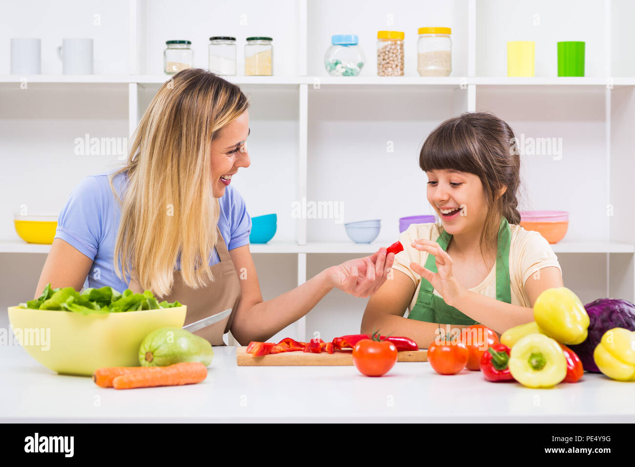 Glückliche Mutter und ihrer Tochter genießen Sie gesunde Mahlzeit zusammen, an ihrem Haus. Stockfoto