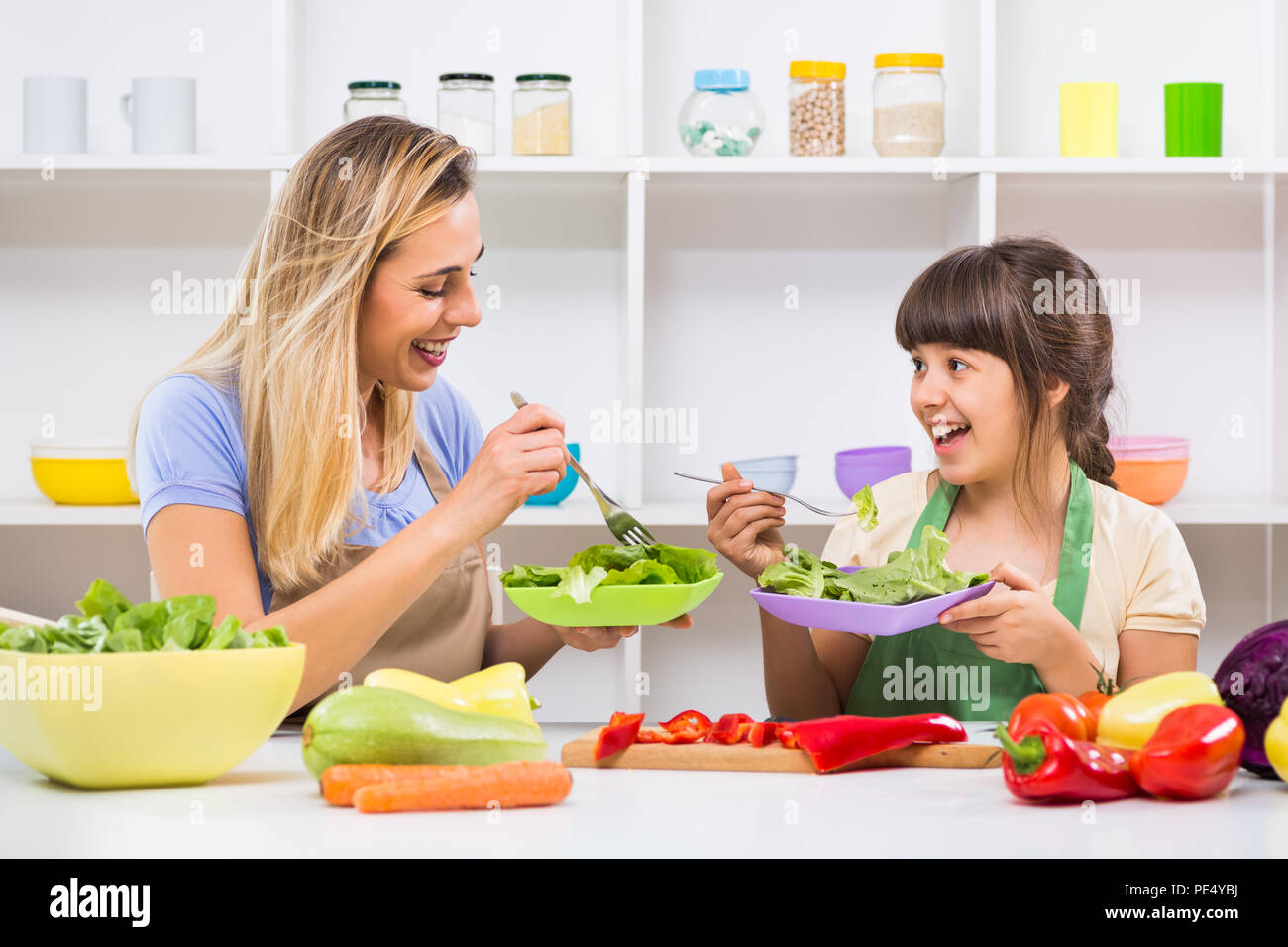 Glückliche Mutter und ihrer Tochter genießen Sie machen und gesunde Mahlzeit zusammen, an ihrem Haus. Stockfoto