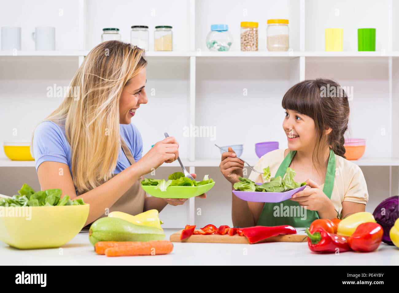 Glückliche Mutter und ihrer Tochter genießen Sie machen und gesunde Mahlzeit zusammen, an ihrem Haus. Stockfoto