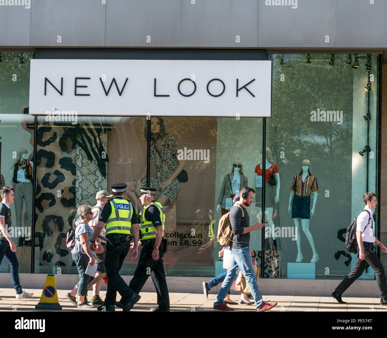Käufer und Polizisten hinter die Fassade des neuen Store mit Puppen in Glas Fenster schauen, Princes Street, Edinburgh, Schottland, Großbritannien Stockfoto