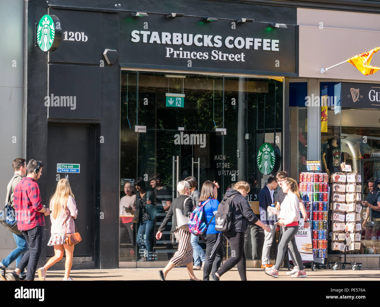 Die Menschen hinter der Fassade von Starbucks Coffee Shop, Princes Street, Edinburgh, Schottland, UK bei sonnigem Sommerwetter Stockfoto