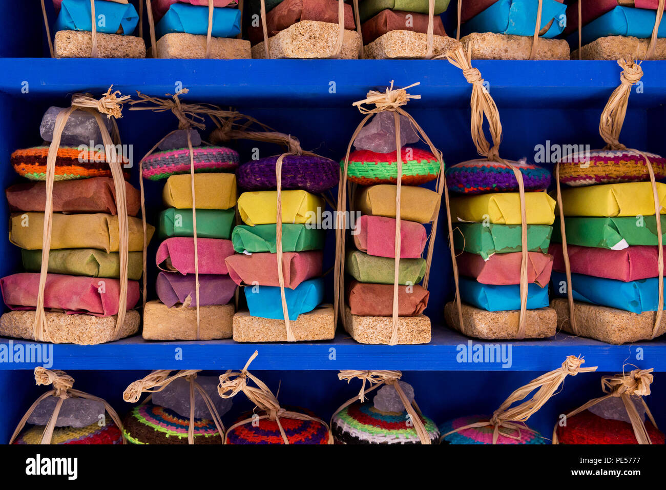 Bunte geschichtete Gewürze, verpackt in klaren Beuteln und mit Schnur auf einem Marktregal in Fes, Marokko, gebunden. Stockfoto