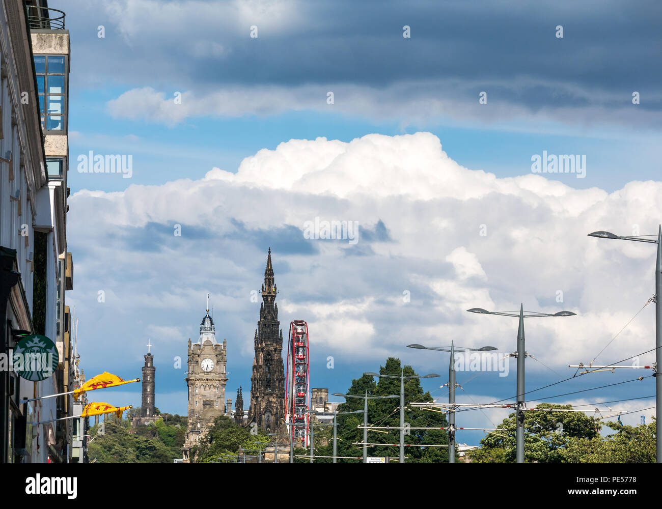 Blick entlang der Princes Street mit obenliegender Straßenbahn Drähte, Scott Monument, Balmoral Hotel Clock Tower und M&Ds großen Riesenrad während der Festival Saison Sommer Stockfoto