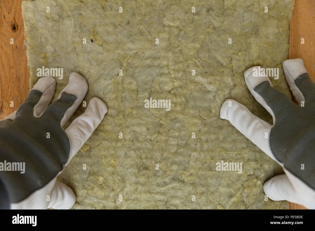 Mann Installation von thermische Isolierung des Daches Layer - mit Mineralwolle Panels. Dachgeschoss Sanierung und Isolierung Konzept Stockfoto