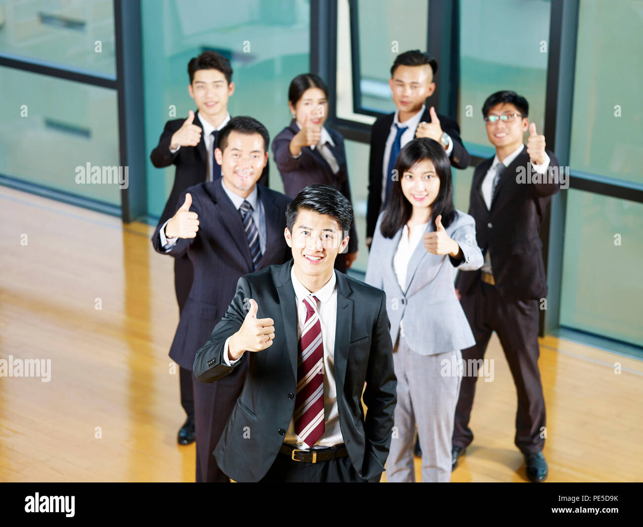 Team von asiatischen Geschäftsleuten mit Daumen - melden Sie sich an. Stockfoto