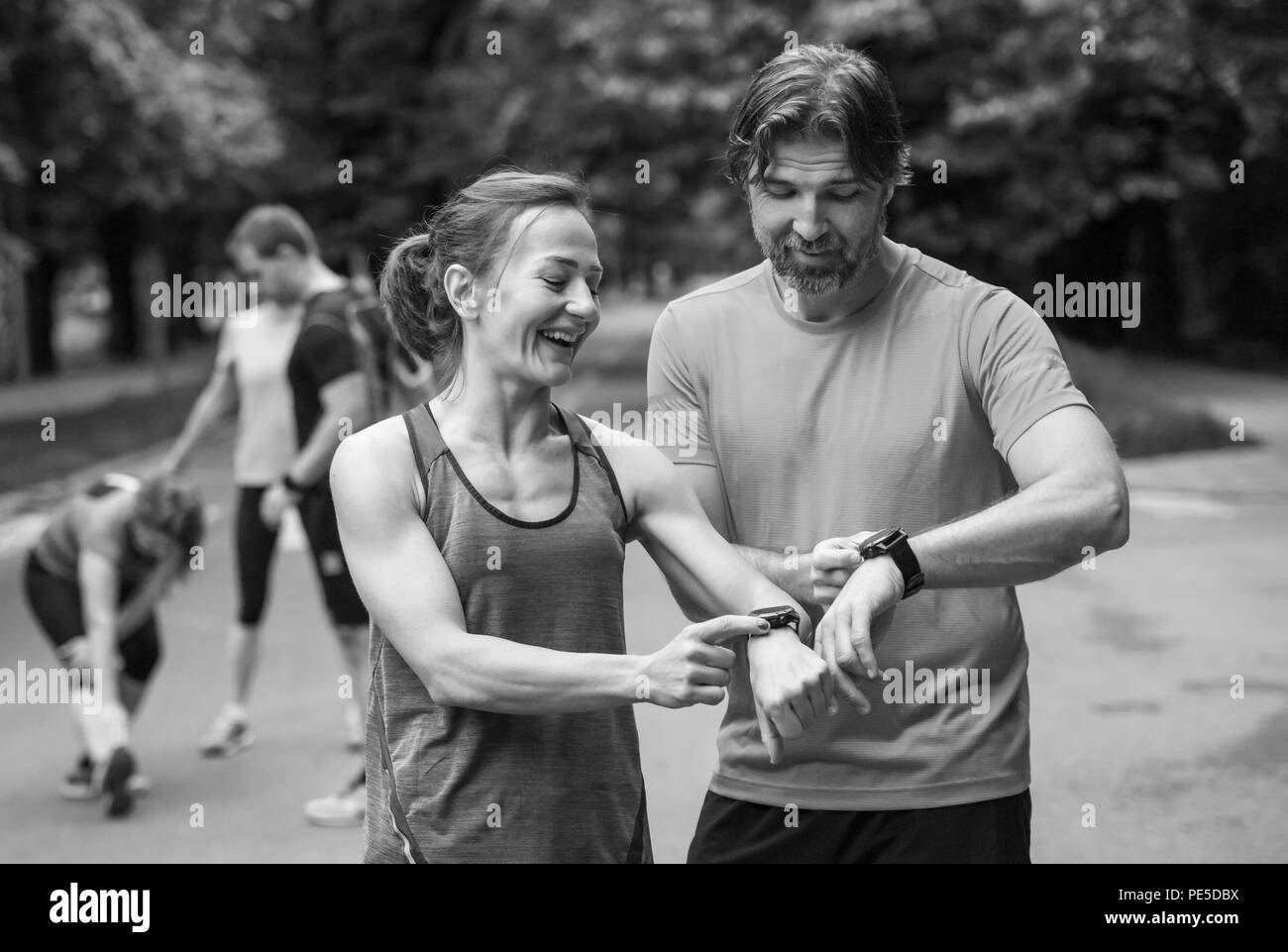 Junge sportliche Paar mit smart Uhren beginnen, ihre Timer vor dem Joggen Stockfoto