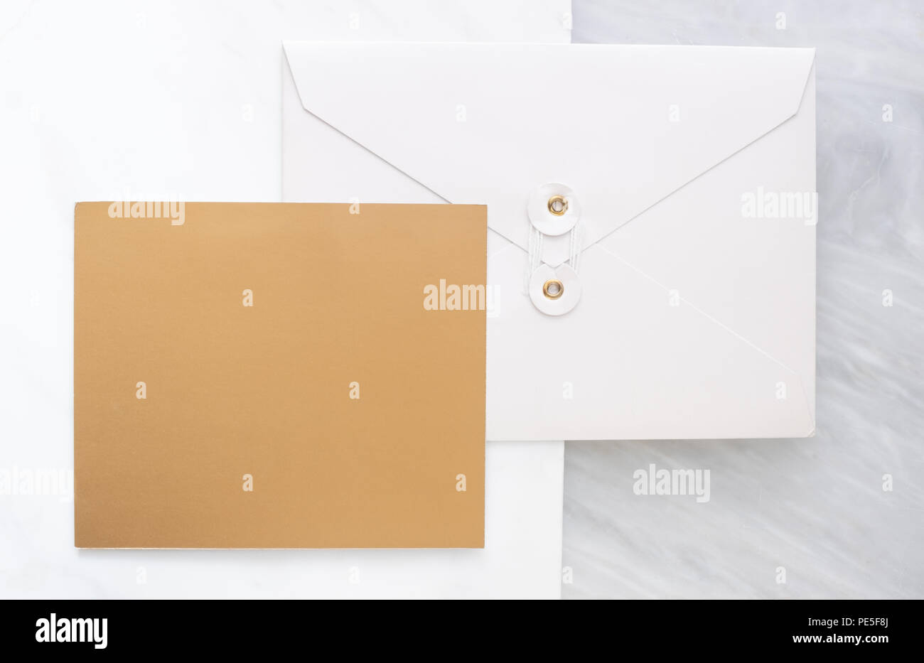 Blick von oben auf die leere Gold Card überschneiden sich auf weißen Briefumschlag auf zwei Layer Schritt von Marmor tisch. Mock up Template für die Anzeige von Design. Luxury Business ite Stockfoto