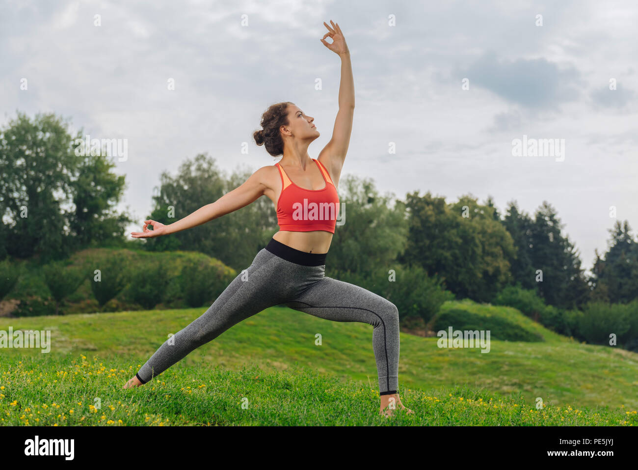 Dunkelhaarige Frau, die gute Stimmung während Yoga Stockfoto