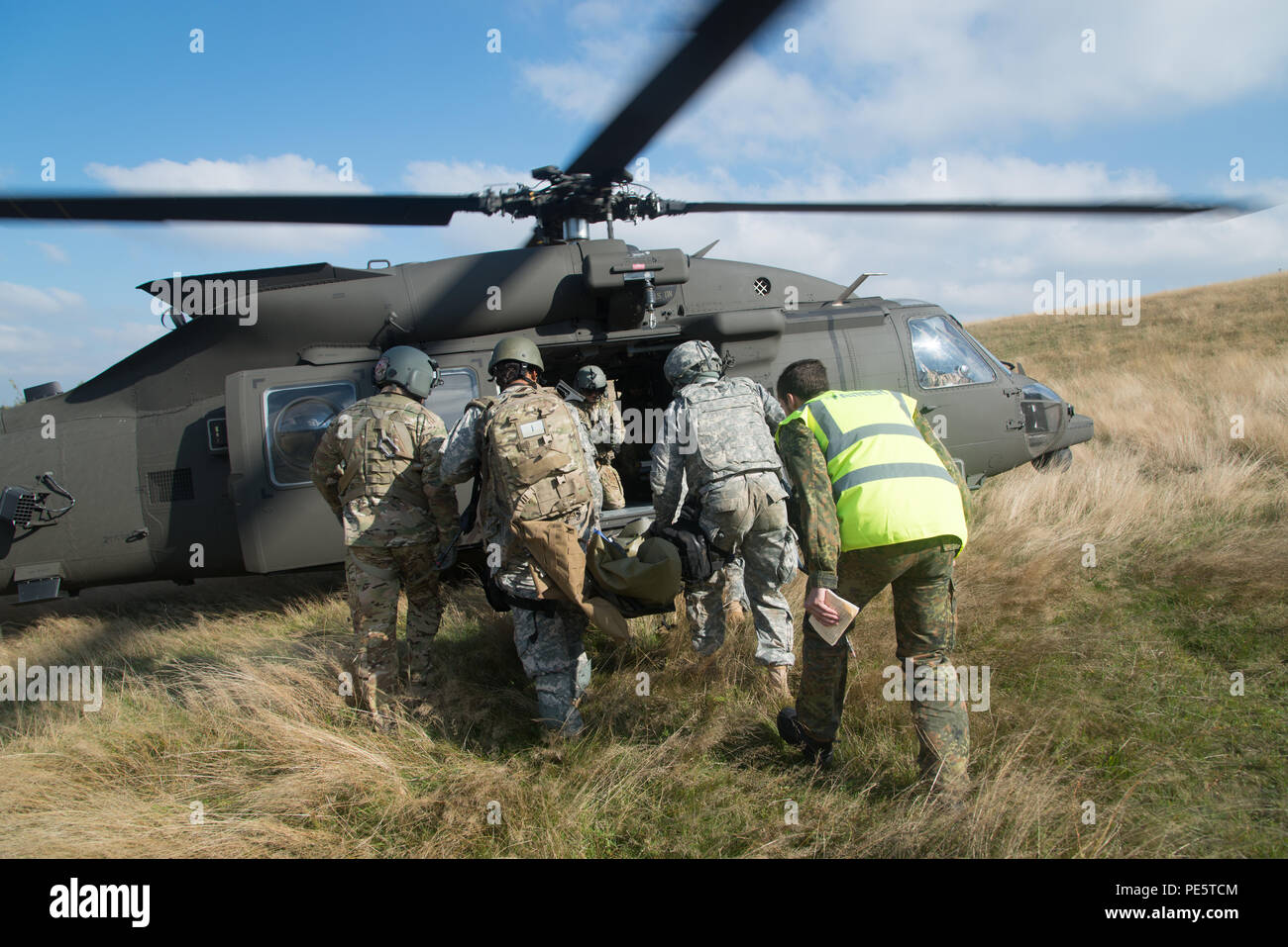 Multinationale Soldaten tragen einen simulierten Unfall auf dem Weg zu einer noch Black Hawk Hubschrauber während einer medizinischen Evakuierung Übung während der Tactical Combat Casualty Care Kurs, die Soldaten aus den USA, Italien, Deutschland, Norwegen, Dänemark und den Niederlanden an der International Special Training Center's, Train the Trainer Kurs, in dem die Hälfte der Teilnehmer Tactical combat Casualty care Lernen und die andere Hälfte Lernen, die Bekämpfung der Unfall- Kurs zu unterrichten. Das Training wurde von General Staufer Kaserne, Sept. 30, 2015 (USA durchgeführt. Armee Foto von visuellen Informationen Spezialist Ma Stockfoto