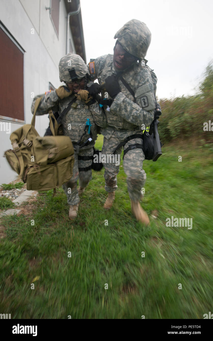 Us-Soldaten bewegen einen simulierten Verluste während Tactical Combat Casualty Care Kurs, dass multinationale Soldaten aus den USA, Italien, Deutschland, Norwegen, Dänemark und den Niederlanden an der International Special Training Center's, Train the Trainer Kurs, in dem die Hälfte der Teilnehmer Tactical combat Casualty care Lernen und die andere Hälfte Lernen, die Bekämpfung der Unfall- Kurs zu unterrichten. Das Training wurde von General Staufer Kaserne, Sept. 30, 2015 (USA durchgeführt. Armee Foto von visuellen Informationen Spezialist Martin Greeson/Freigegeben) Stockfoto