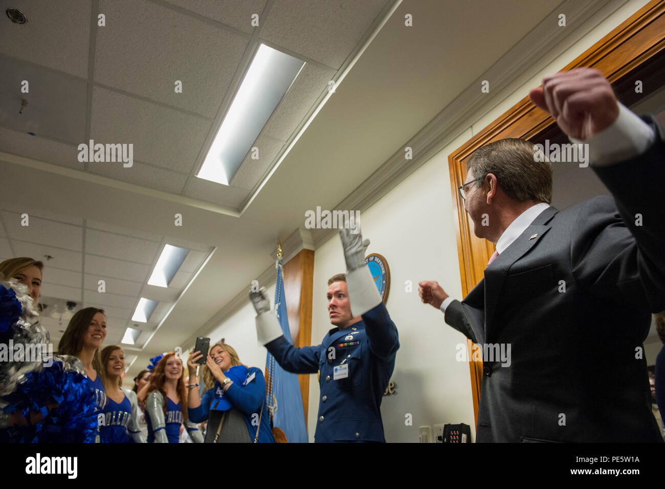 Verteidigungsminister Asche Carter hilft jubeln und direkt der US Air Force Academy Band und Cheerleadern während einer Air Force Academy pep Rally am Pentagon Okt. 2, 2015 am Vorabend der Air Force Academy versus Naval Academy football Spiel. (DoD Foto von Senior Master Sgt. Adrian Cadiz/Freigegeben) Stockfoto