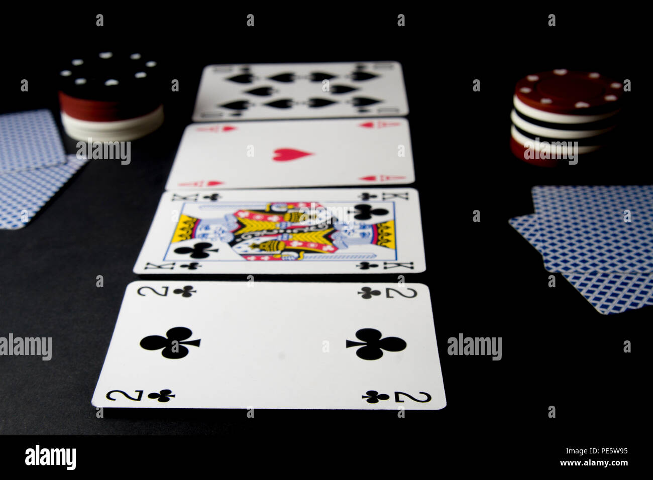 Poker Karten und Chips isoliert auf Schwarz. Flache Freiheitsgrad. Heads Up, Fluss und Stapel Chips, Blinds auf dem Tisch. Stockfoto