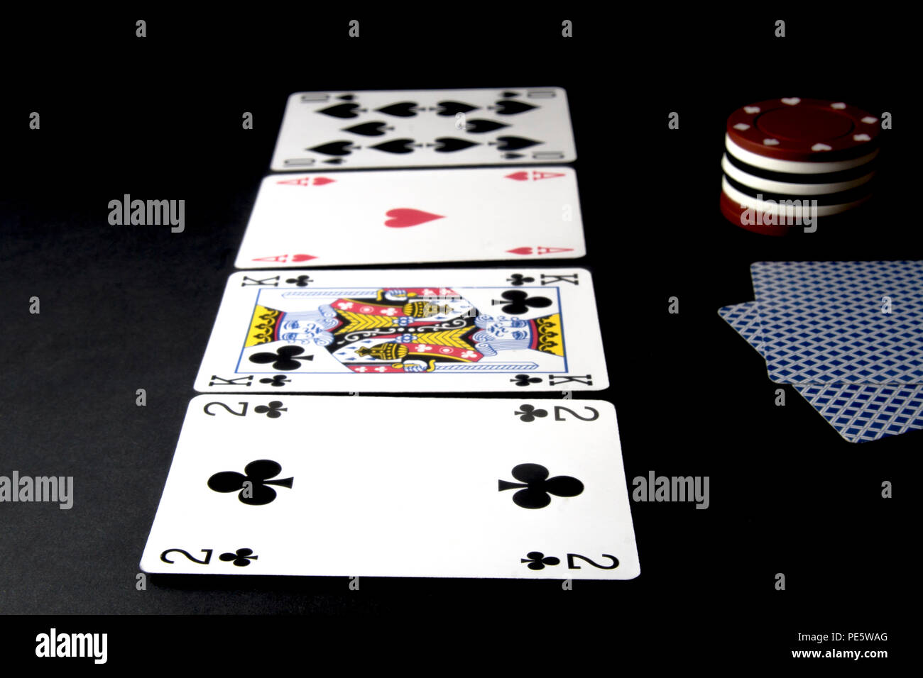 Poker Karten und Chips isoliert auf Schwarz. Fluss auf dem Tisch mit Händen und Jalousien. Flache Freiheitsgrad. Stockfoto