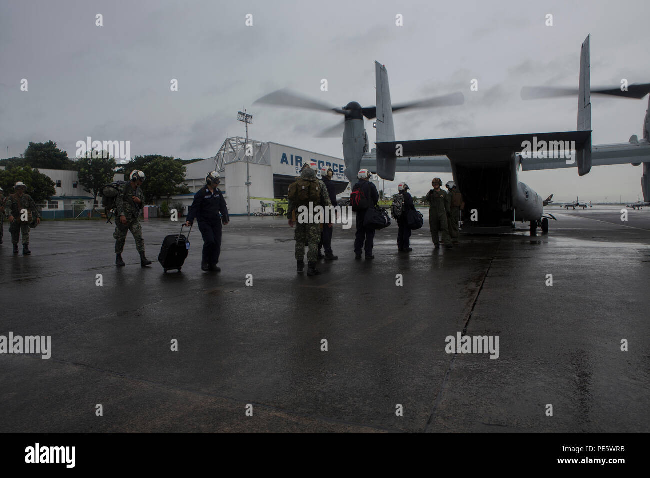 Us-Marines mit Marine Medium Tilt rotor Squadron-265, 3. Marine Expeditionary Force, und der Philippinischen service Mitglieder, Vorstand ein MV-22 Osprey während amphibische Landung Übung 2015 an der Clark Air Base, Philippinen, Okt. 2. 15 PHIBLEX ist eine jährliche, bilateralen Training durch die US-Marine und Marine Kräfte, die mit der Streitkräfte der Philippinen, um die Interoperabilität zu stärken und die Zusammenarbeit im Bereich der militärischen Operationen von der Katastrophenhilfe bis hin zu komplexen expeditionary Operations. (U.S. Marine Corps Foto von Lance Cpl. Juan Bustos/Freigegeben) Stockfoto