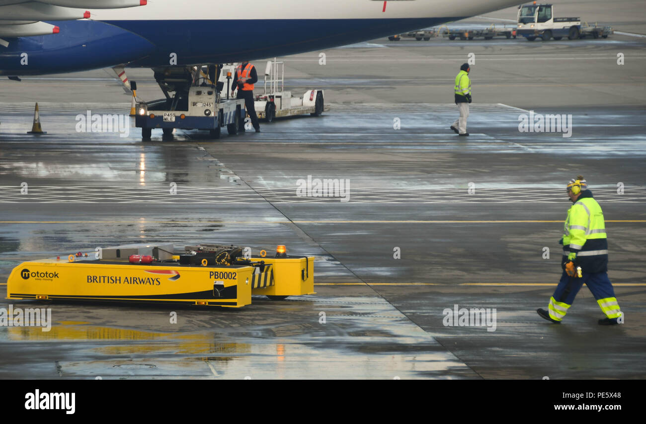 Flughafen Arbeiter Verschieben einer ferngesteuerten tug Zurück zum Terminal 5 am Flughafen London Heathrow nach Zurückschieben der scheidende British Airways Flugzeug Stockfoto
