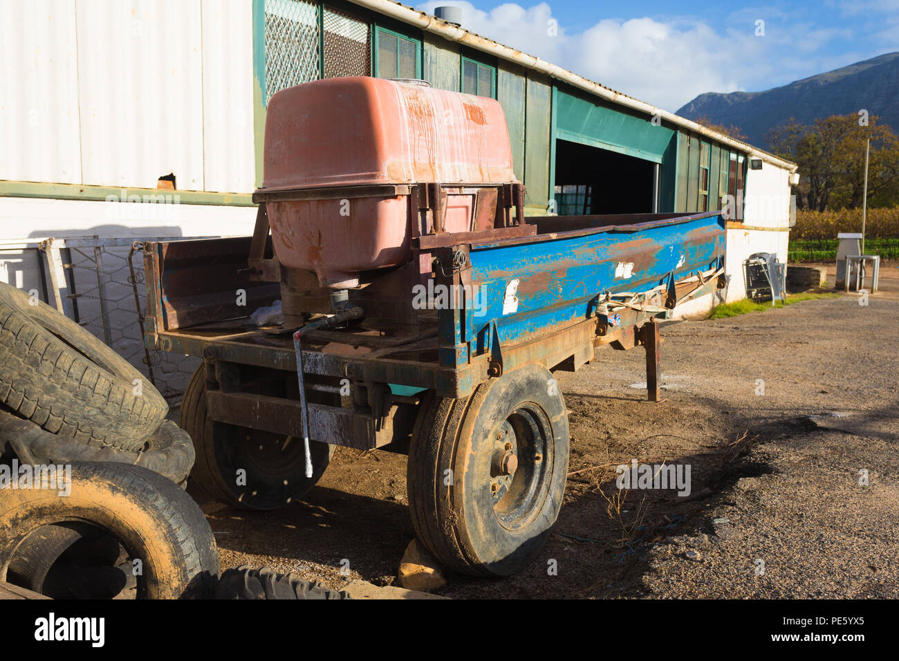 Abgestellte Anhänger mit Feldspritze in die Weinberge oder Weinbau Industrie im Freien neben einem Schuppen auf einem Weingut in Kapstadt geladen Stockfoto Abgestellte Anhänger mit Feldspritze in die Weinberge oder Weinbau Industrie im Freien neben einem Schuppen auf einem Weingut in Kapstadt geladen Stockfoto
