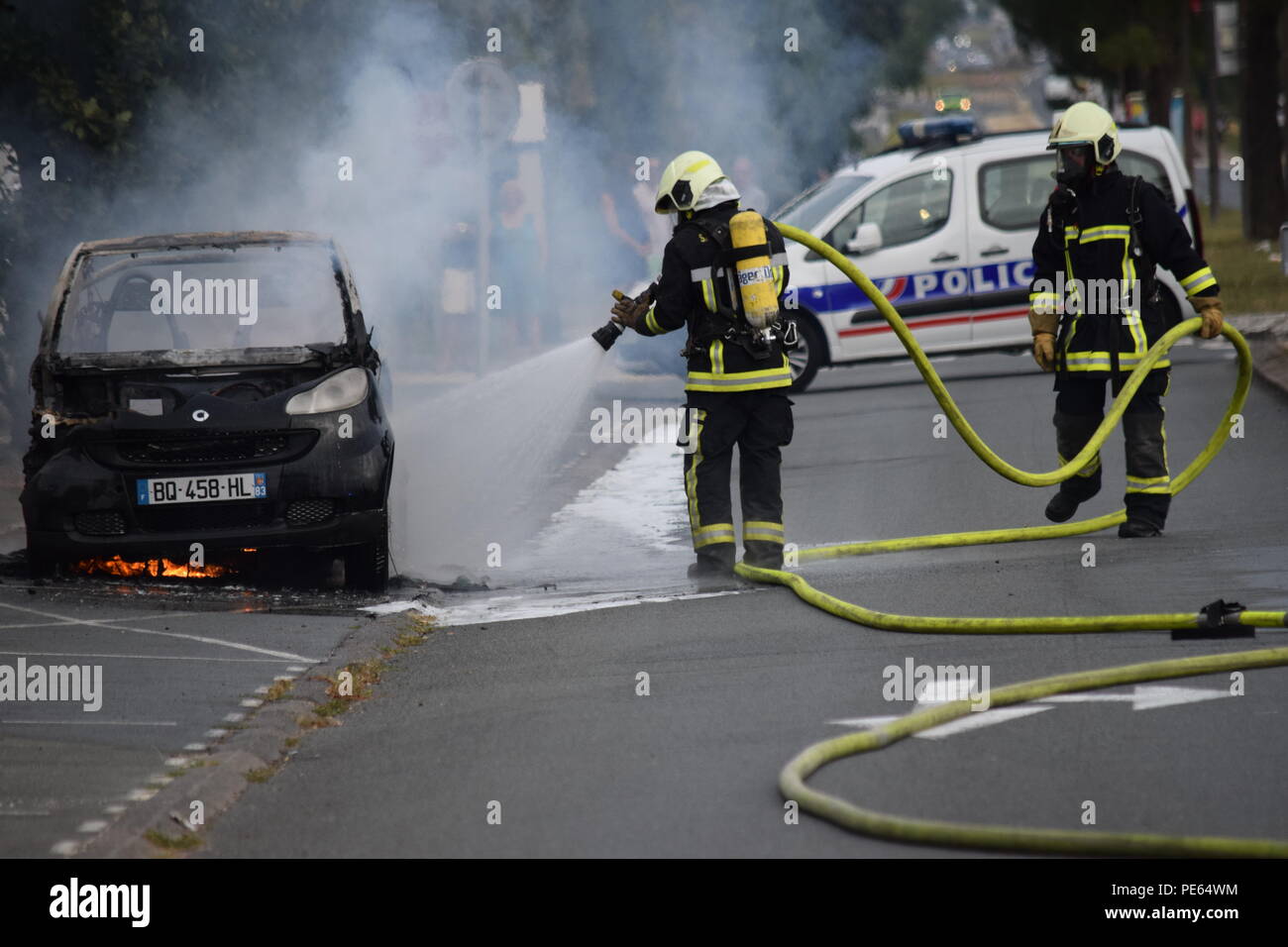 Aytré, Frankreich. 12. Aug 2018. Brach ein Feuer auf einen Smart Fortwo Fahrzeug auf der Straße, General de Gaulle Avenue, in Aytré am späten Nachmittag am Sonntag, den 12. August 2018. Wir sehen die Intervention der Feuerwehrmänner, die löschen, was aus dem Auto gelassen wird. Credit: Fabrice Restier/Alamy leben Nachrichten Stockfoto