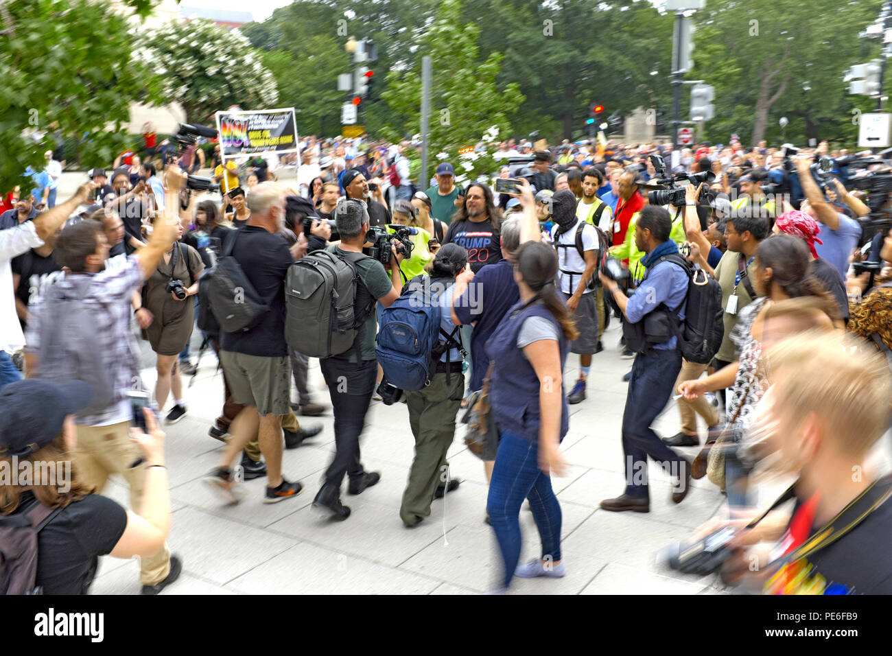 Washington D.C., USA. 12 August, 2018. Ein alt-rechten Unterstützer verlässt die "Unite das Recht 2'-Rallye im Lafayette Park zu einer Masse von counterprotesters und Fotografen. In einem Trumpf 2020 t-shirt bekleidet, der Mann versucht, die Rallye zu verlassen, während Leute an ihn schreien. Das Foto wurde genommen, bevor er Polizei Schutz in der Nähe gesucht. Credit: Mark Kanning/Alamy Leben Nachrichten. Stockfoto