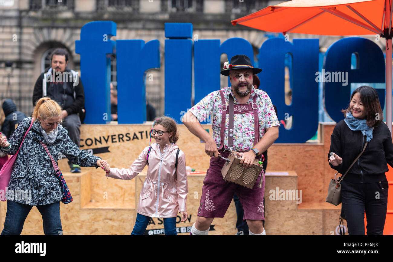 Edinburgh, Schottland, Großbritannien. Am 13. August 2018. Eine Street Performer unterhält Touristen im Regen und Nieselregen auf der Royal Mile in der Altstadt von Edinburgh. Credit: Ben Collins/Alamy leben Nachrichten Stockfoto