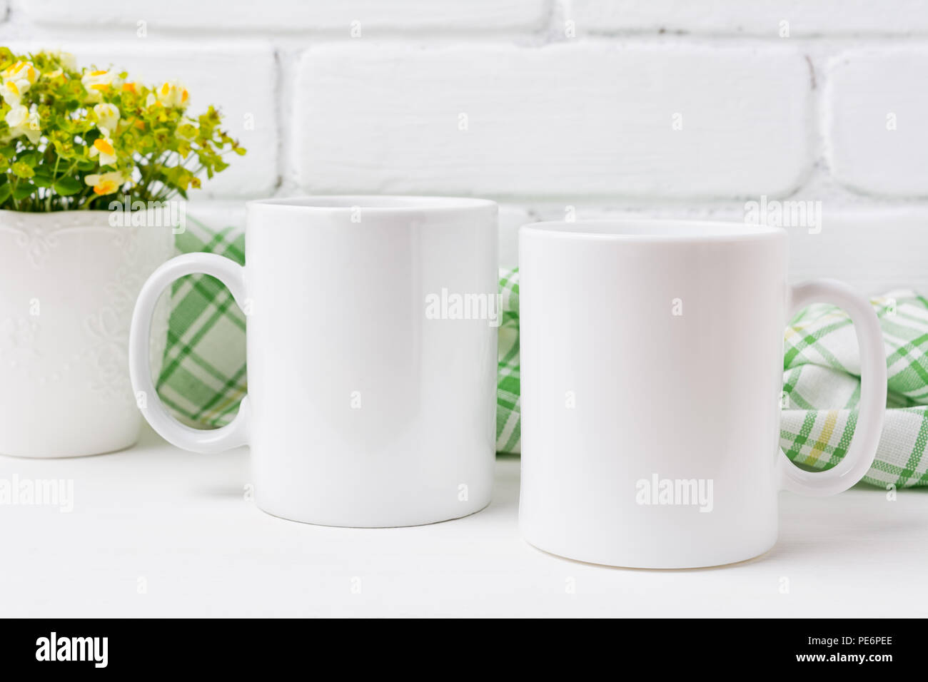 Zwei weiße Kaffeetasse mockup mit kleinen gelben und grünen Blumen. Leere Becher mock up für Design Promotion. Stockfoto