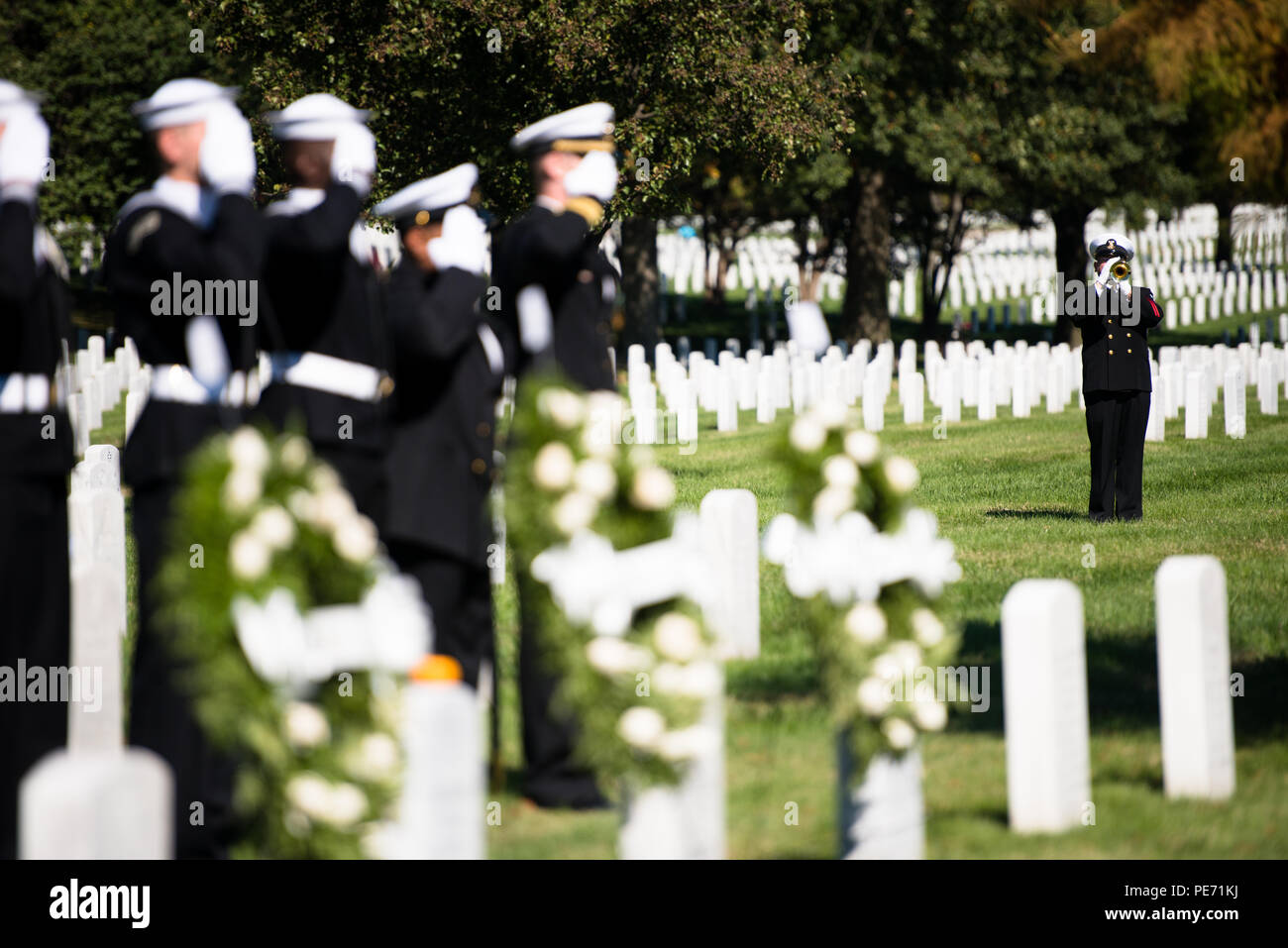 Am 12. Oktober 2015 spielte ein Bugler Taps auf dem Arlington National Cemetery in Arlington, Virginia, während einer Zeremonie zu Ehren der 17 amerikanischen Seeleute, die beim Terroranschlag der USS Cole am 12. Oktober 2000 getötet wurden. Die Veranstaltung beinhaltete Kränzlegen und Erinnerungsaktivitäten in Abschnitt 60, wobei die Teilnahme der U.S. Navy die historische Bedeutung, den Militärdienst, die Opfer und die zeremonielle Einhaltung hervorhob. Stockfoto