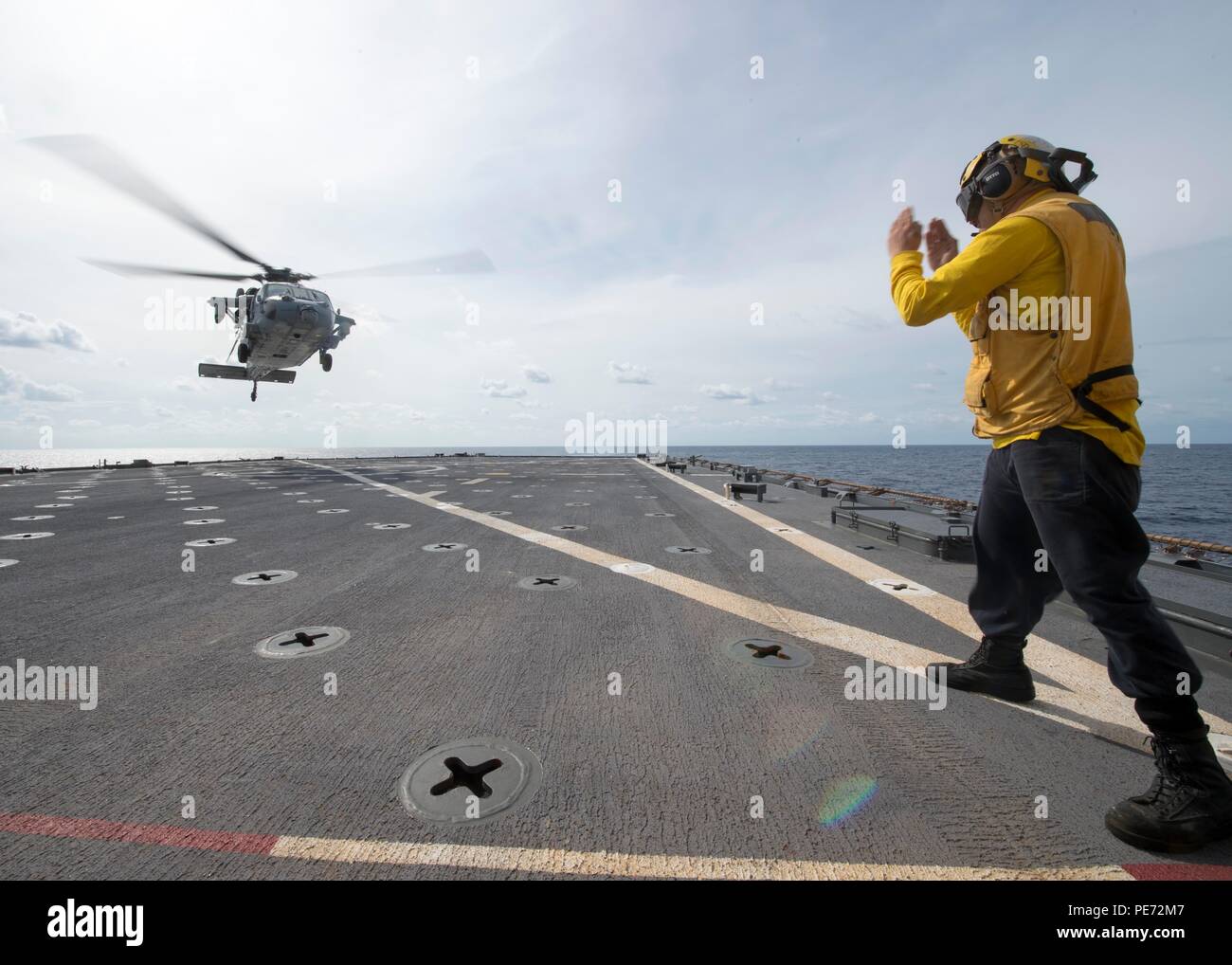 151010-N-JO 245-045 ATLANTIK (Okt. 2010) 10, 2015) - der bootsmann Mate 3. Klasse Leo Biggs leitet ein MH-60S Seahawk auf das Flight Deck der Amphibischen dock Landung Schiff USS Oak Hill (LSD 51). Die kearsarge Amphibious Ready Gruppe (KSGARG) und 26 Marine Expeditionary Unit (26 MEU) ist unterwegs zur Unterstützung der Maritime Security Operations und Theater Sicherheit Zusammenarbeit im US-Flotte 5. und 6. Bereich von Operationen. (U.S. Marine Foto von Mass Communication Specialist 2. Klasse Justin Yarborough/Freigegeben) Stockfoto