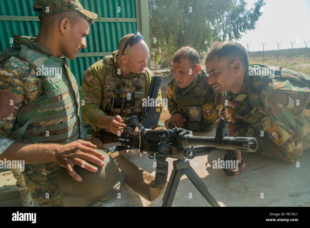 Eine australische Soldaten zugeordnet zu Aufgabengruppe Taji zeigt irakische Soldaten der 71 irakischen Armee Feuerwehr zugewiesen, wie ein Funktionen prüfen auf einem M249 Light Machine Gun während der Schlacht zu führen - die Aufgabe Ausbildung im Camp Taji, Irak, Okt. 10, 2015. Die australische Soldaten war, die einen fortgeschrittenen Kurs, wie die Waffe funktioniert. Dieses Wissen wird irakische Soldaten helfen, mit besseren Treffsicherheit im Kampf gegen die Islamischen Staat im Irak und der Levante. (U.S. Armee Foto von SPC. William Marlow/Freigegeben) Stockfoto
