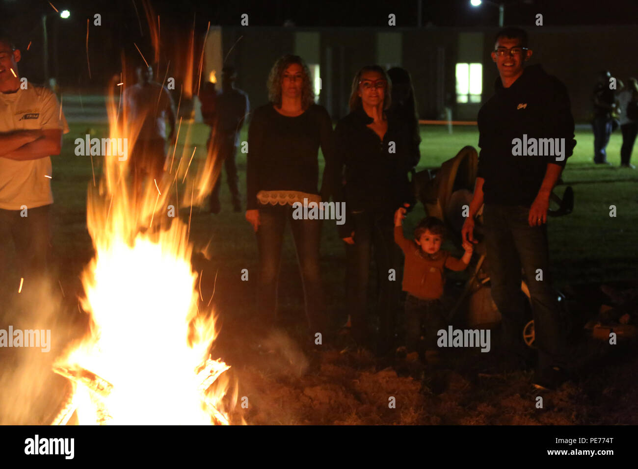 Marines stehen mit ihren Familien, da Sie Warm-up, das von einem Feuer im Herbst Familie Festival von Marine Air Control Squadron 2 bei Marine Corps Air Station Cherry Point, N.C., Okt. 22, 2015 gehostet wird. Mehr als 100 Marines, Matrosen und Familie versammelte sich aus den Herbst mit einem Chili Kochen zum Kick-off und Kostümwettbewerb sowie Spiele, einen Film und ein Lagerfeuer. (U.S. Marine Corps Foto von Cpl. N.W. Huertas/Freigegeben) Stockfoto